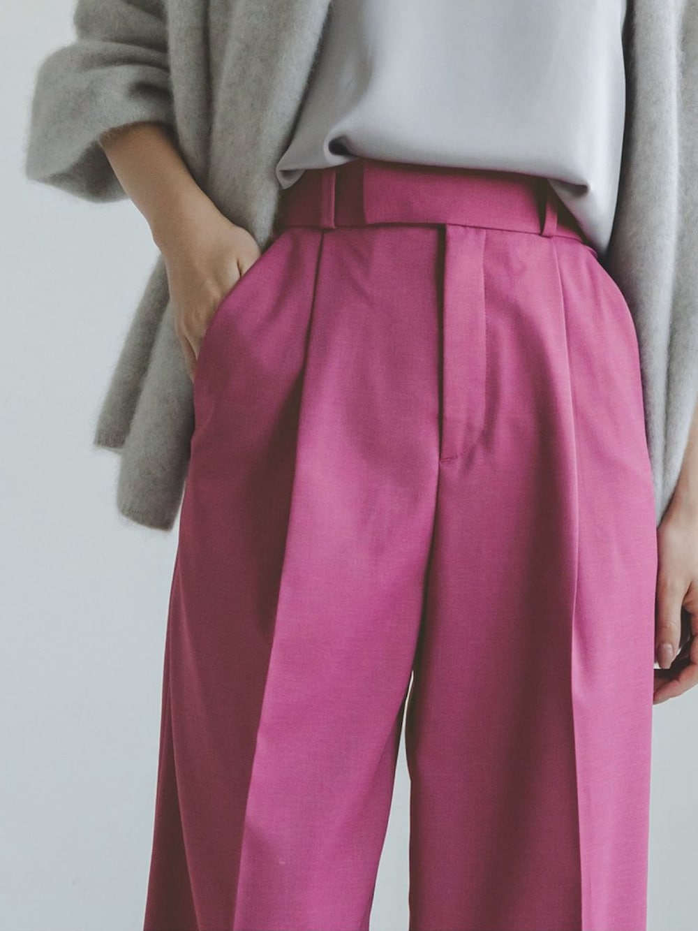 グレー系のタンクトップ、グレー系のカーディガン/ボレロ、ピンク系のスラックスを着用したレディースの秋コーディネートの3枚目の写真