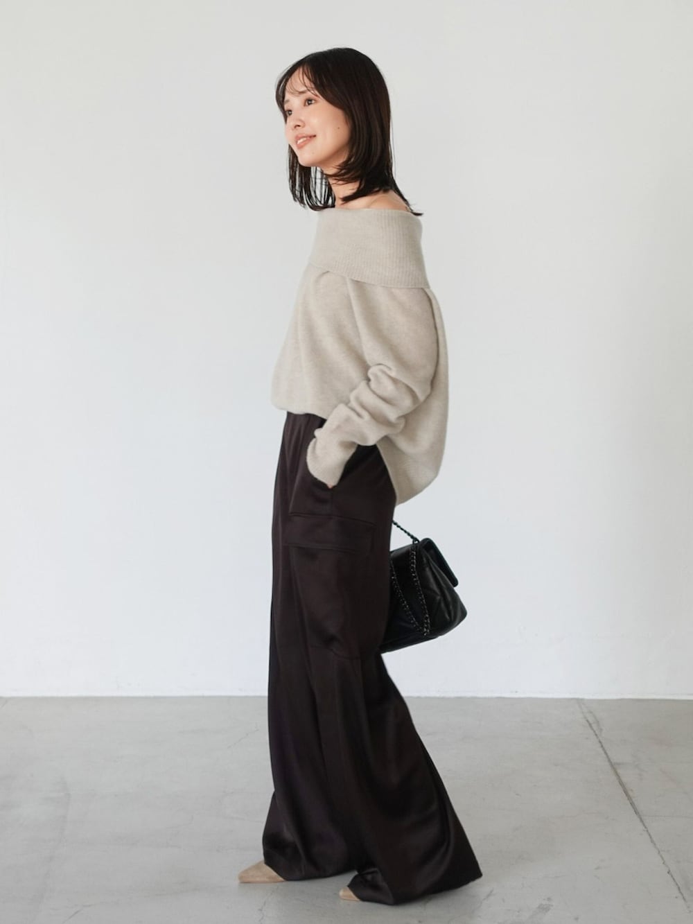 ブラウン系のカーゴパンツ、ベージュ系のニット/セーター、ブラック系のショルダーバッグを着用したレディースの夏コーディネートの4枚目の写真