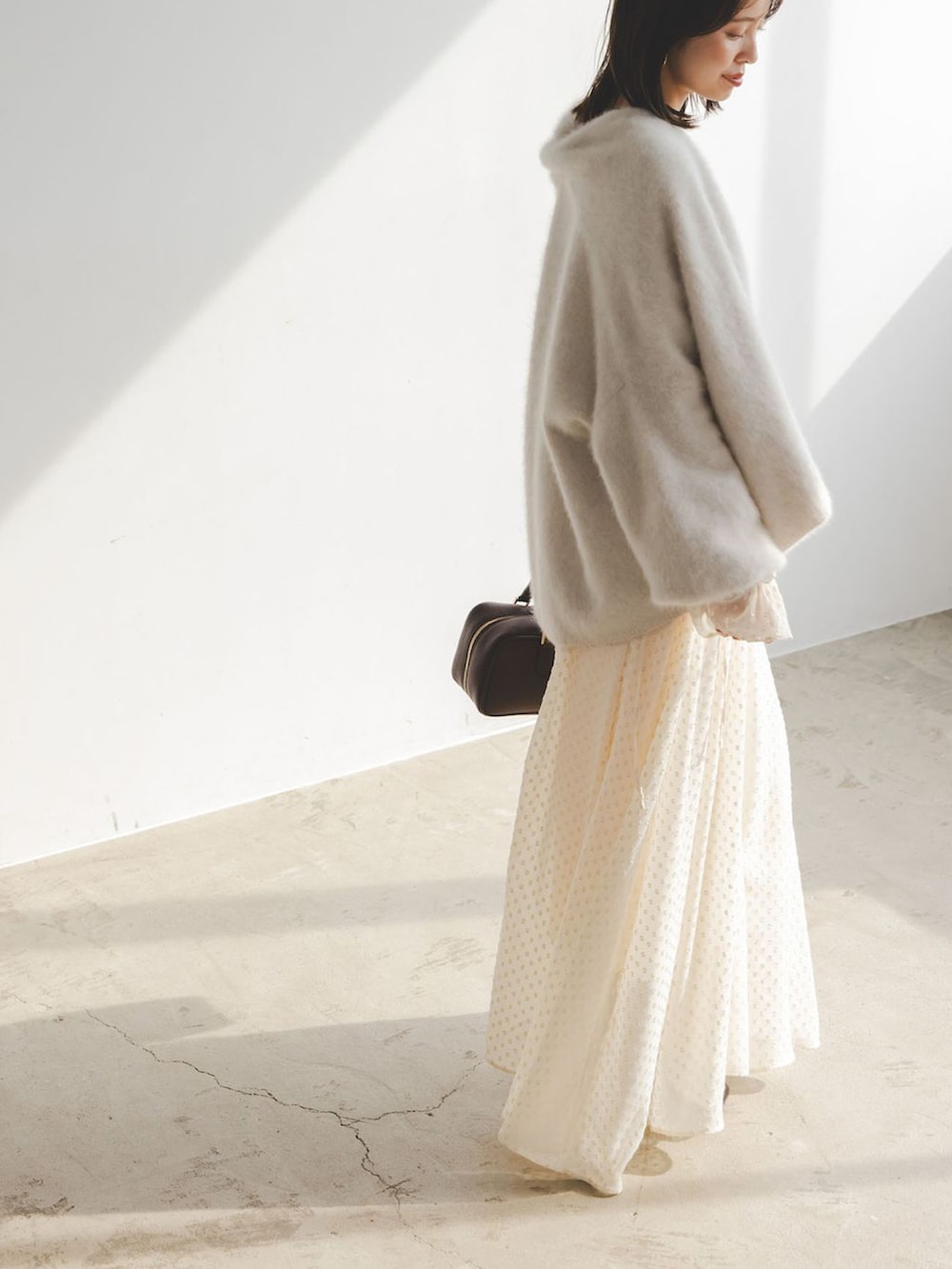 ベージュ系のワンピース、ベージュ系のカーディガン/ボレロ、ブラウン系のボストンバッグを着用したレディースの秋コーディネートの4枚目の写真