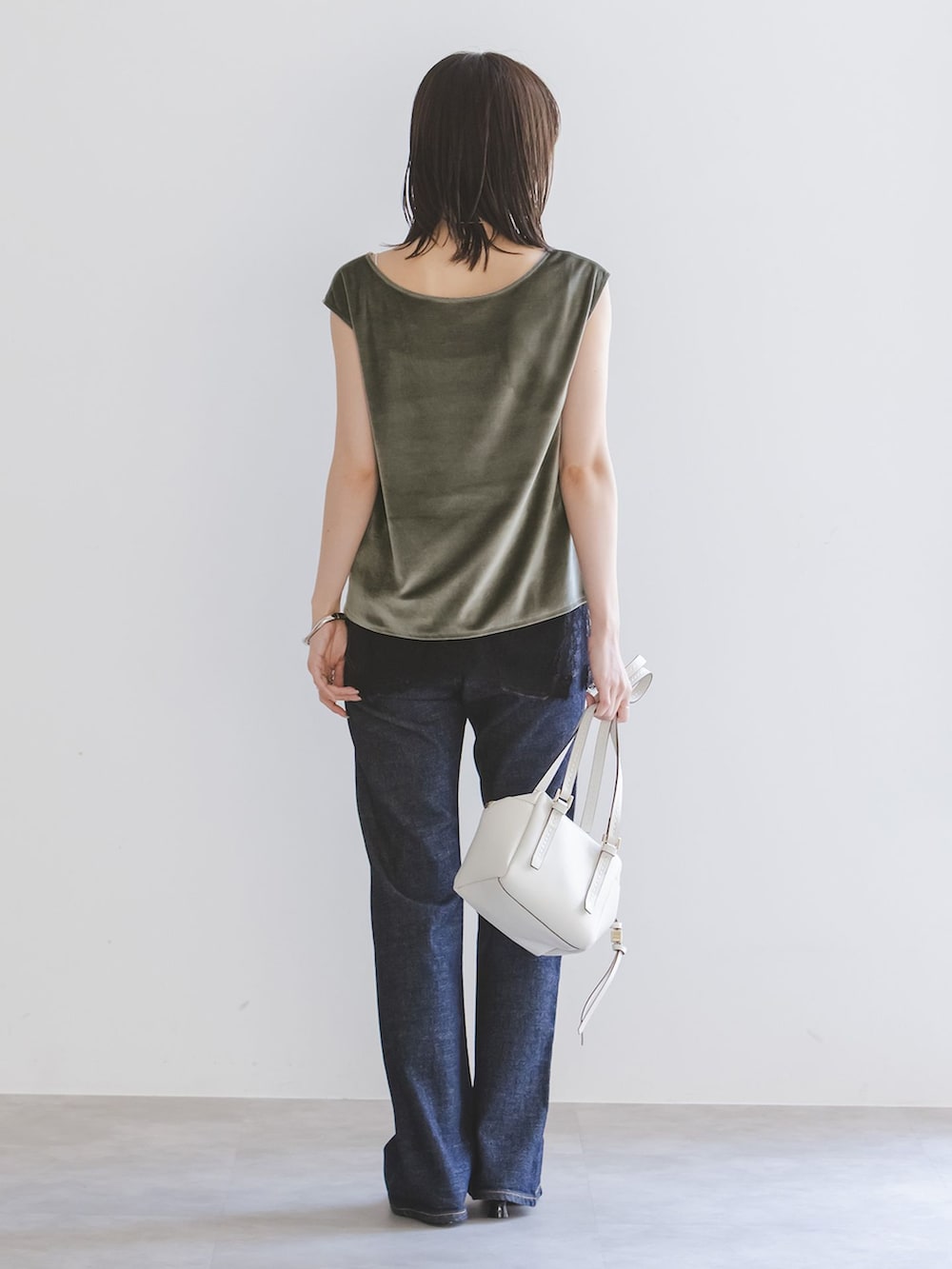 ブルー系のデニムパンツ、ブラック系のキャミソール、グリーン系のTシャツ/カットソーを着用したレディースの夏コーディネートの3枚目の写真
