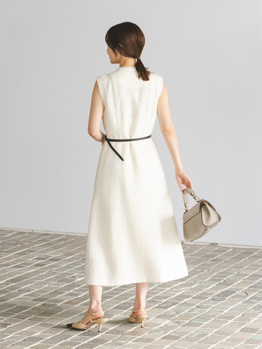 ホワイト系のワンピース、グレー系のショルダーバッグ、ブラック系のベルトを着用したレディースの秋コーディネートの2枚目の写真