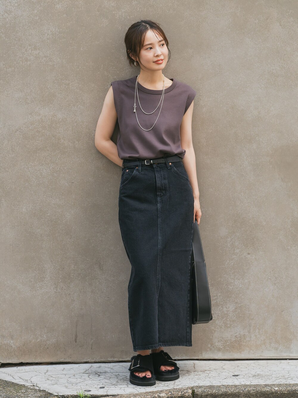 ブラウン系のTシャツ/カットソー、ブラック系のデニムスカート、ブラック系のサンダルを着用したレディースの夏コーディネートの3枚目の写真