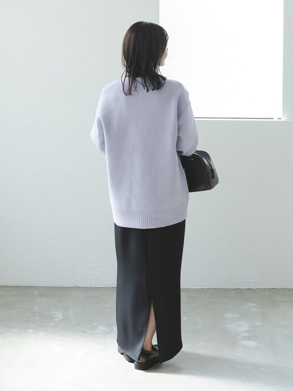 ブルー系のカーディガン/ボレロ、ブラック系のワンピース、ブラウン系のハンドバッグを着用したレディースの秋コーディネートの3枚目の写真