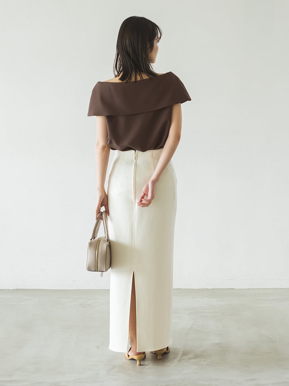 ブラウン系のシャツ/ブラウス、ホワイト系のスカート、ベージュ系のショルダーバッグを着用したレディースの春コーディネートの2枚目の写真
