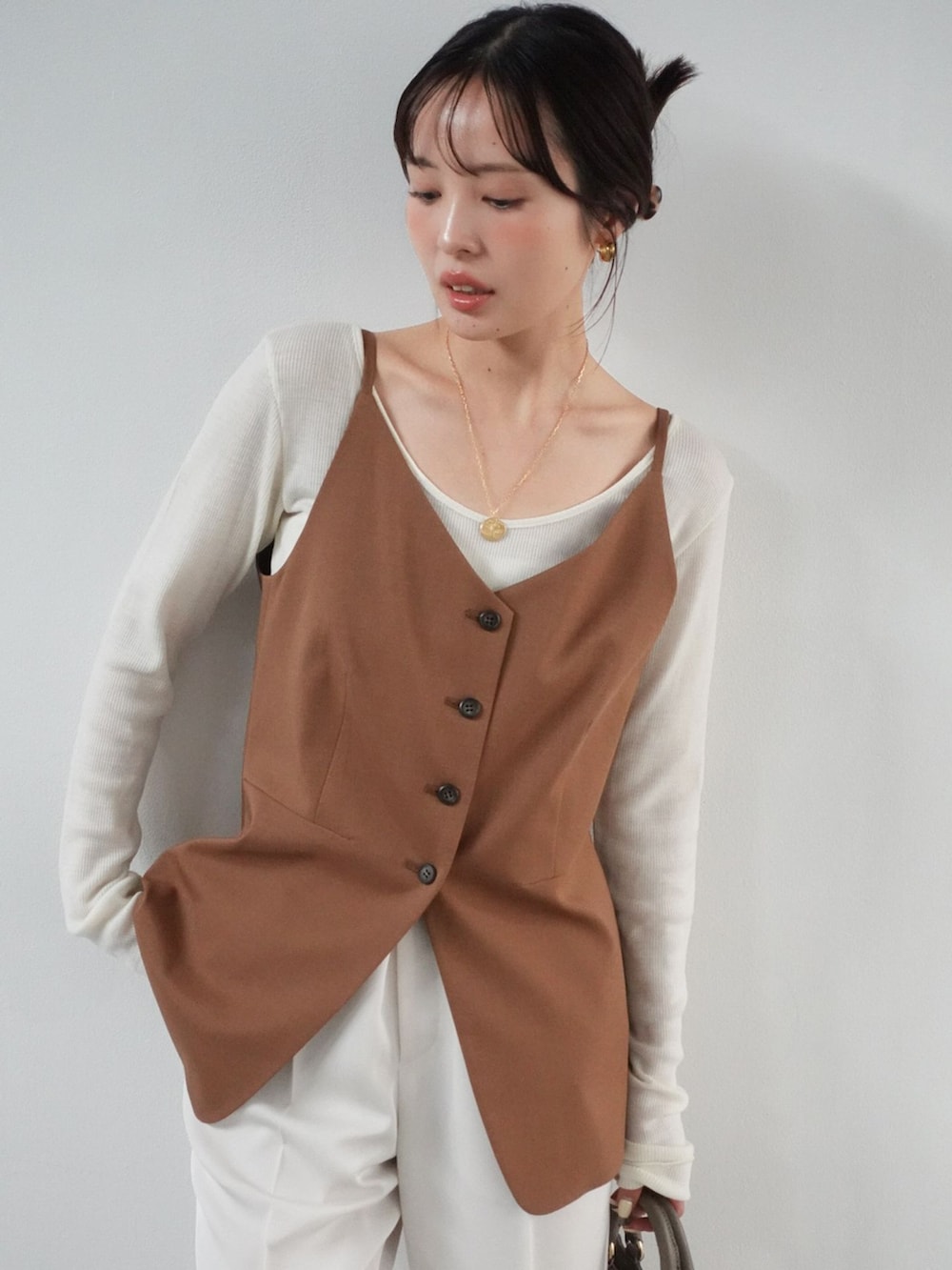 ホワイト系のスラックス、イエロー系のシャツ/ブラウス、ホワイト系のTシャツ/カットソーを着用したレディースの夏コーディネートの4枚目の写真