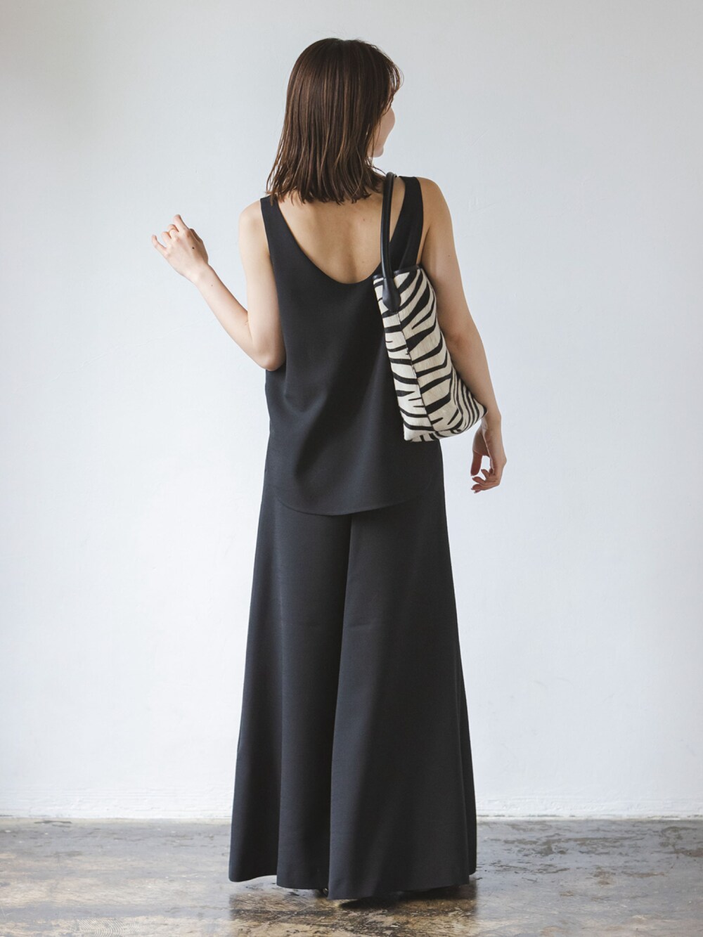 ブラック系のワンピースを着用したレディースの夏コーディネートの2枚目の写真