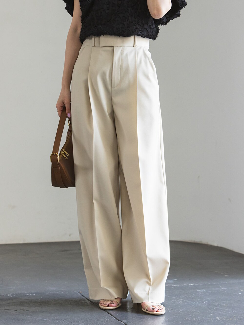 ベージュ系のスラックス、ブラック系のシャツ/ブラウス、ベージュ系のサンダルを着用したレディースの夏コーディネートの3枚目の写真