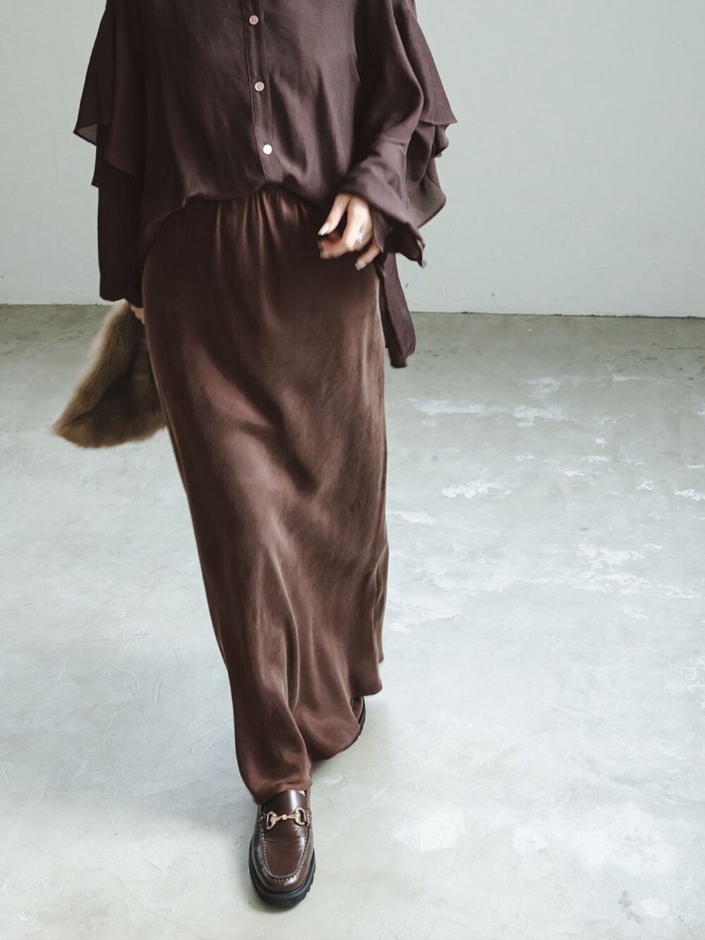 ブラウン系のシャツ/ブラウス、ブラウン系のスカート、ブラウン系のローファーを着用したレディースの秋コーディネートの3枚目の写真