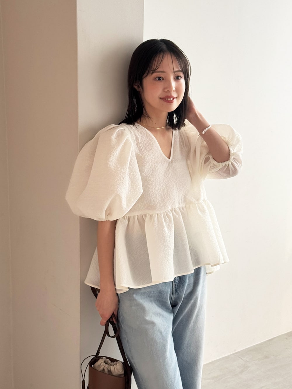 ホワイト系のシャツ/ブラウス、ブルー系のデニムパンツ、ベージュ系のサンダルを着用したレディースの春コーディネートの2枚目の写真