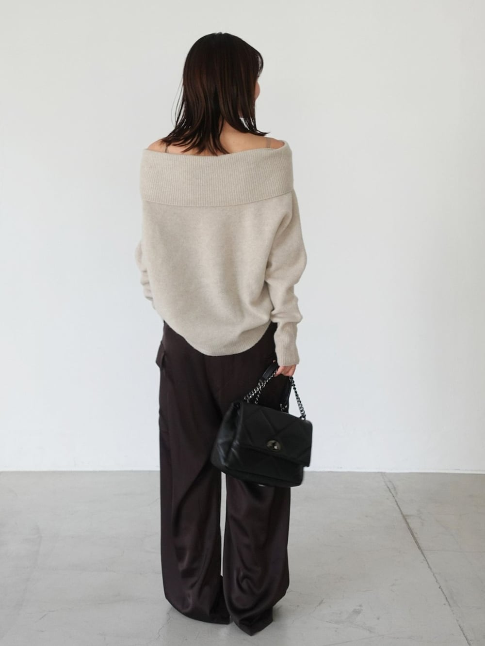 ブラウン系のカーゴパンツ、ベージュ系のニット/セーター、ブラック系のショルダーバッグを着用したレディースの夏コーディネートの3枚目の写真