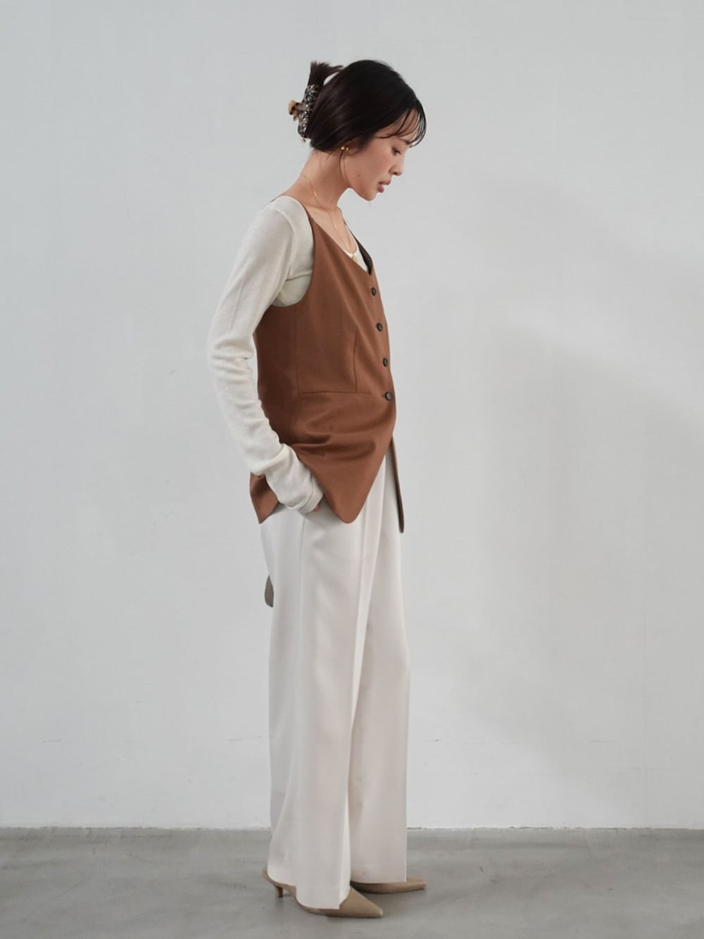 ホワイト系のスラックス、イエロー系のシャツ/ブラウス、ホワイト系のTシャツ/カットソーを着用したレディースの夏コーディネートの2枚目の写真