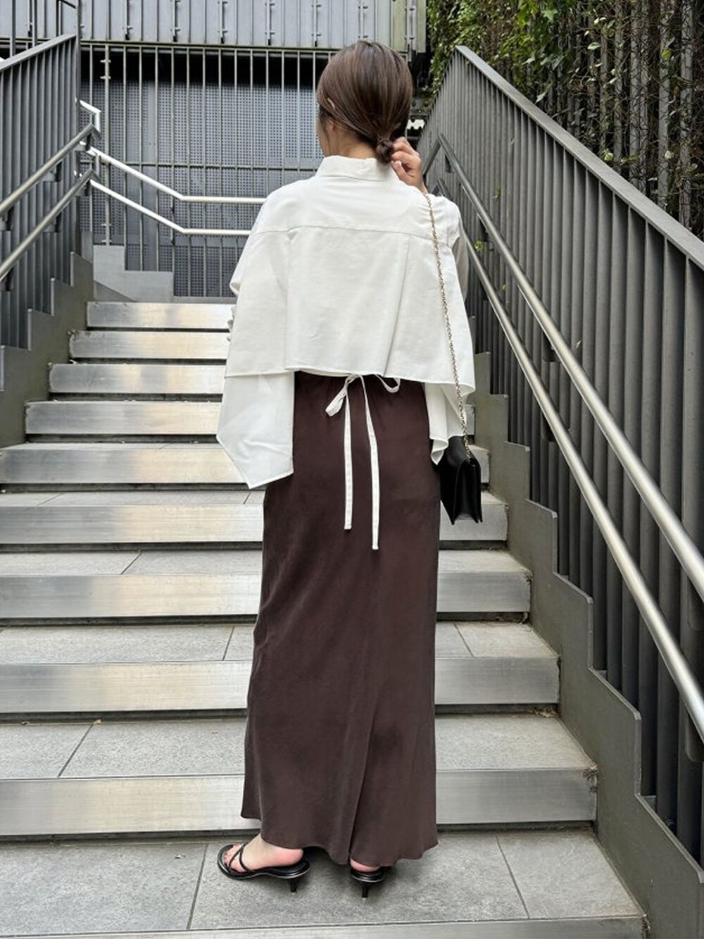 ホワイト系のシャツ/ブラウス、ブラウン系のスカート、ブラック系のサンダルを着用したレディースの夏コーディネートの2枚目の写真