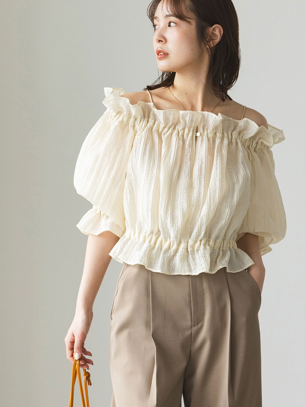 ホワイト系のシャツ/ブラウス、ブラウン系のスラックス、ブラック系のサンダルを着用したレディースの春コーディネートの3枚目の写真