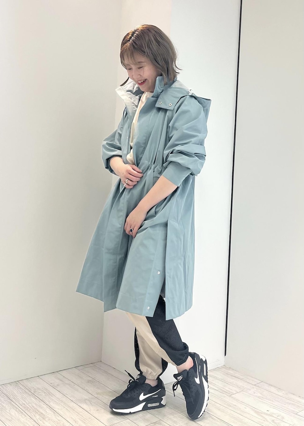 グリーン系のその他アウター、ブラック系のスニーカー、ホワイト系のTシャツ/カットソーを着用したレディースの冬コーディネートの2枚目の写真