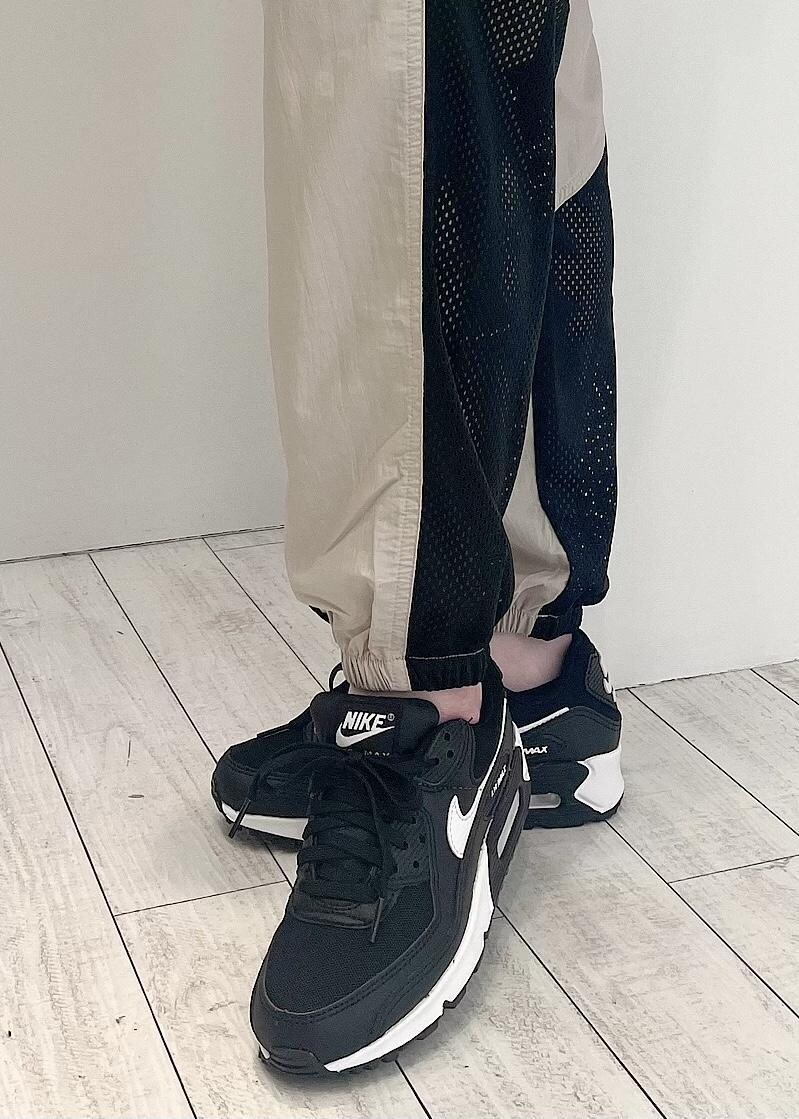 グリーン系のその他アウター、ブラック系のスニーカー、ホワイト系のTシャツ/カットソーを着用したレディースの冬コーディネートの5枚目の写真