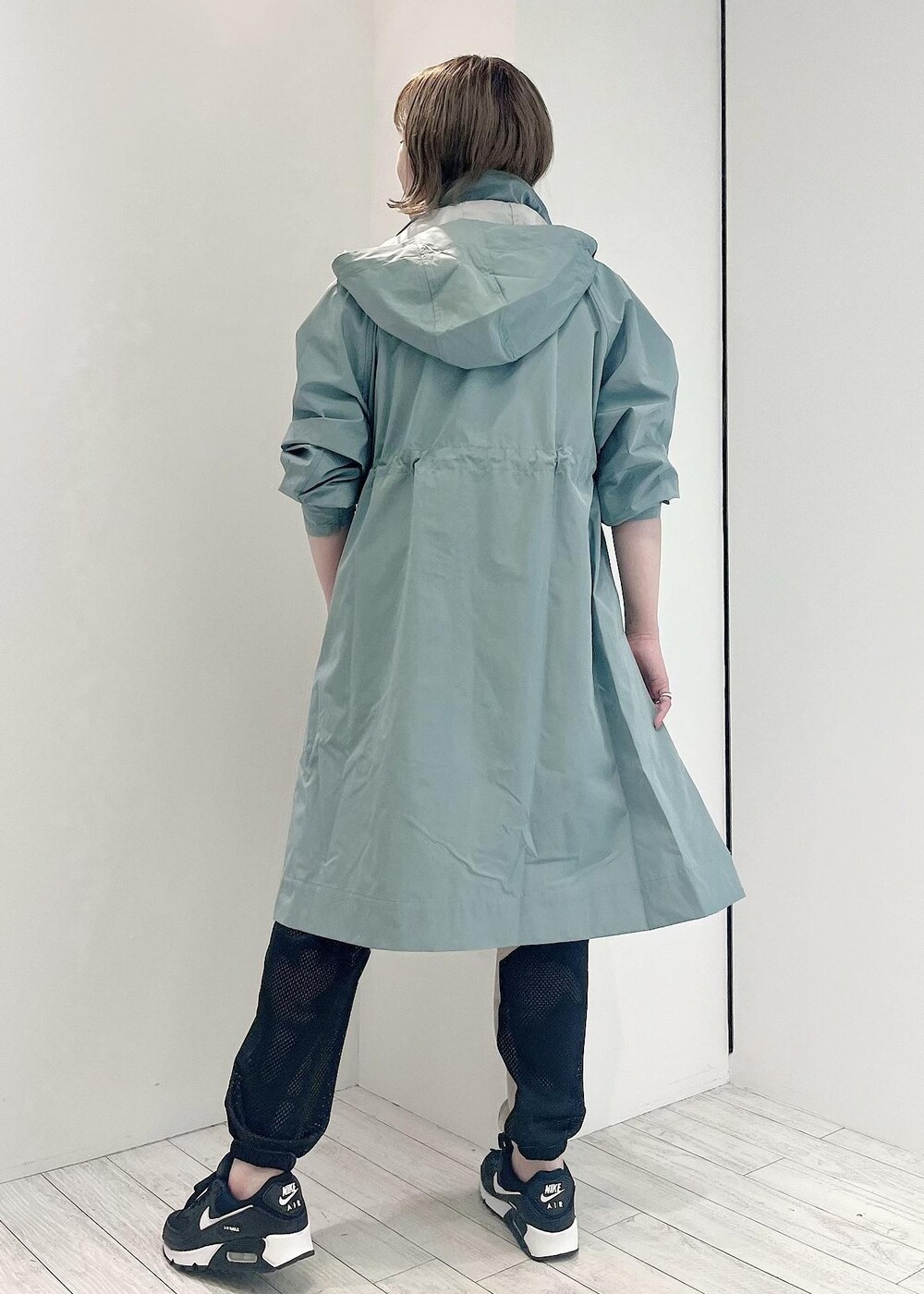 グリーン系のその他アウター、ブラック系のスニーカー、ホワイト系のTシャツ/カットソーを着用したレディースの冬コーディネートの3枚目の写真