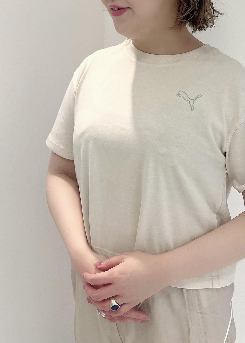 グリーン系のその他アウター、ブラック系のスニーカー、ホワイト系のTシャツ/カットソーを着用したレディースの冬コーディネートの4枚目の写真