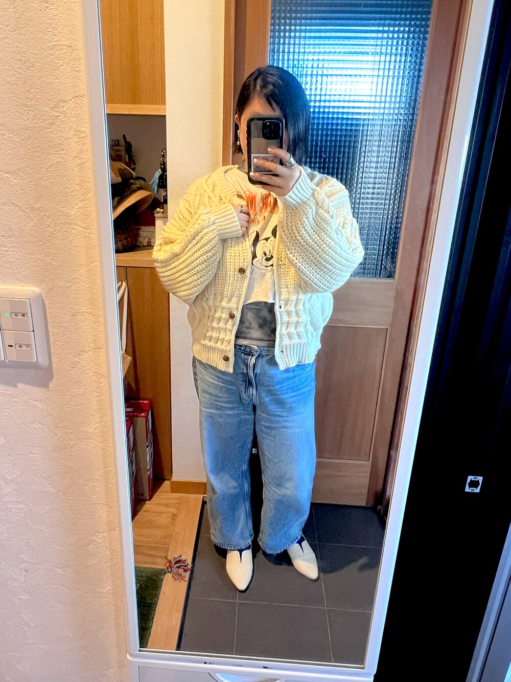 ブルー系のデニムパンツ、グレー系のトップス、グレー系のTシャツ/カットソーを着用したレディースの冬コーディネートの2枚目の写真