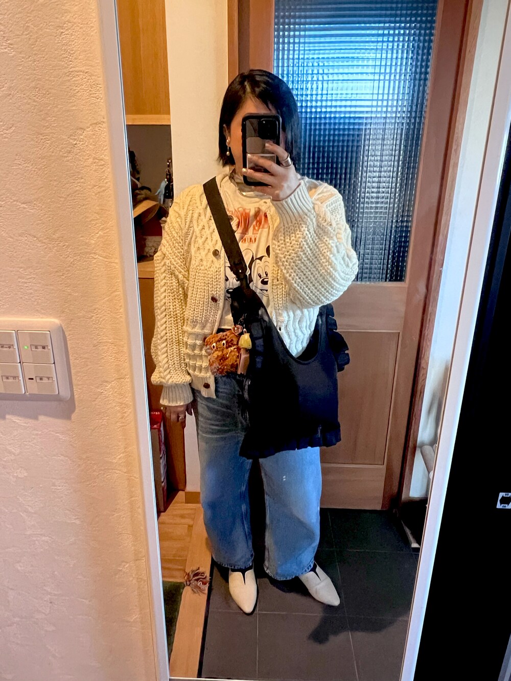 ブルー系のデニムパンツ、グレー系のトップス、グレー系のTシャツ/カットソーを着用したレディースの冬コーディネートの3枚目の写真