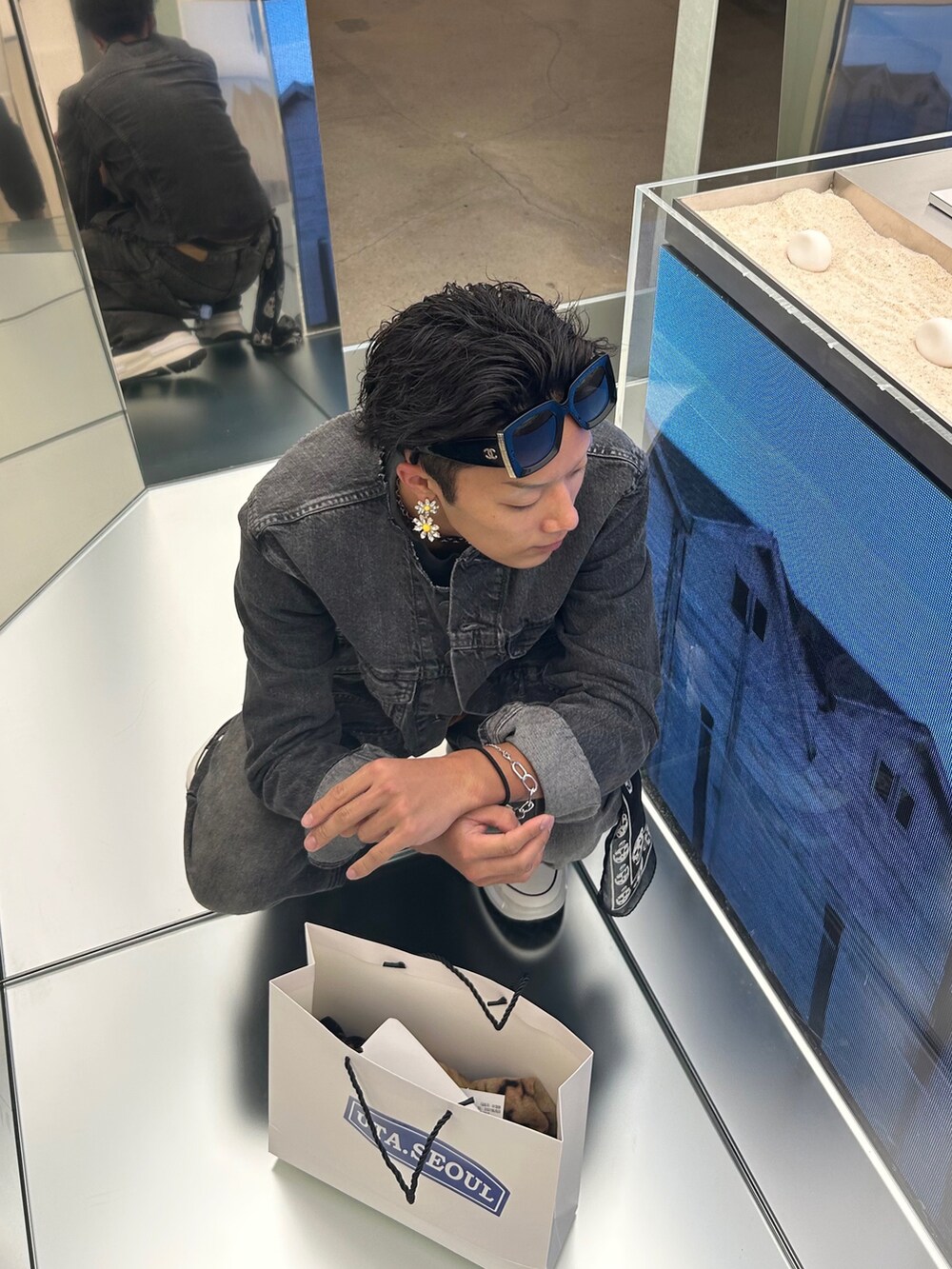 グレー系のデニムジャケット、グレー系のデニムパンツ、ブラック系のスニーカーを着用したメンズの秋コーディネートの4枚目の写真