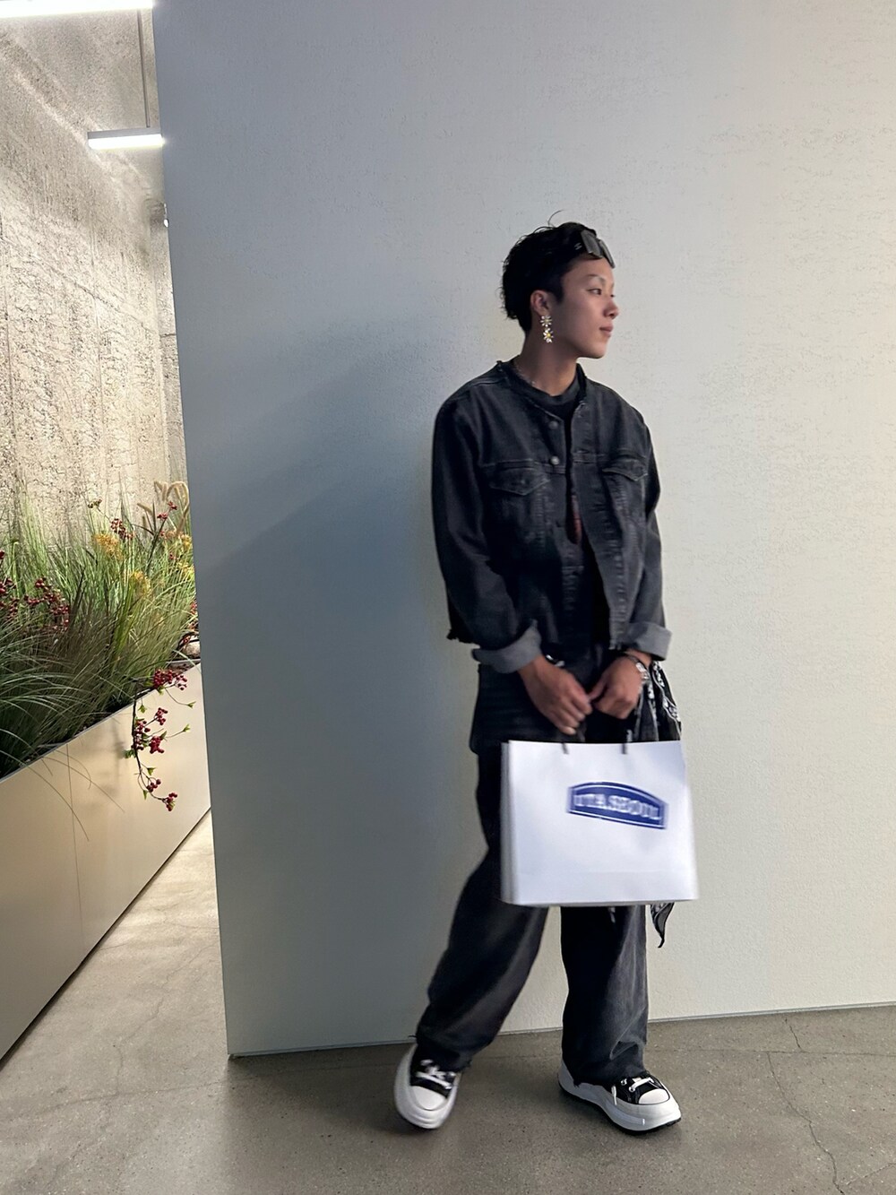 グレー系のデニムジャケット、グレー系のデニムパンツ、ブラック系のスニーカーを着用したメンズの秋コーディネートの2枚目の写真