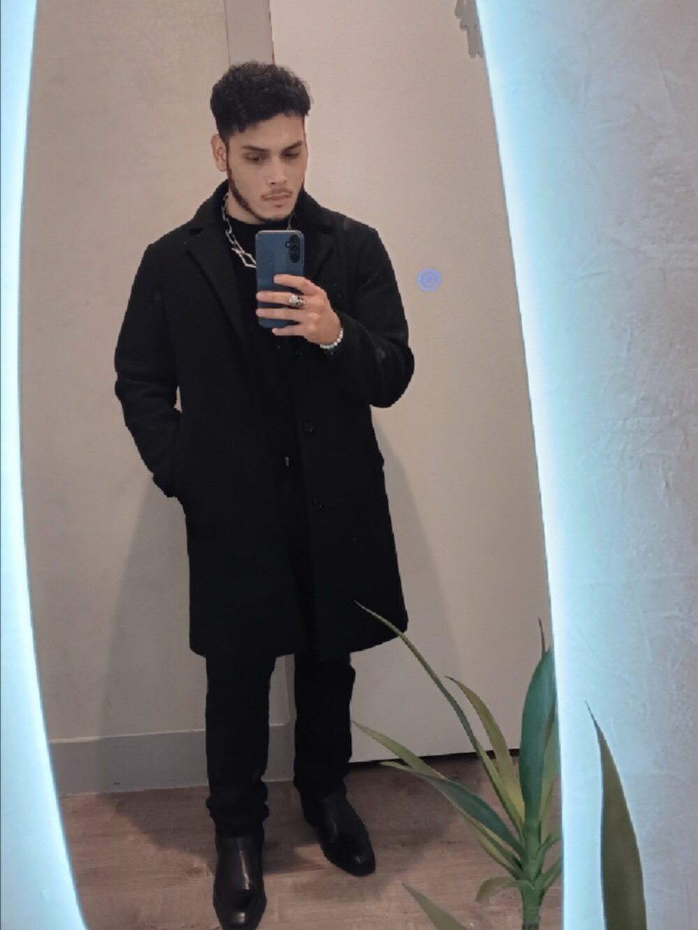 ブラック系のチェスターコートを着用したメンズの冬コーディネートの2枚目の写真