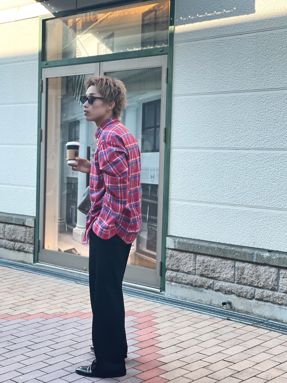 ブラック系のスラックス、ブラック系のブーツを着用したメンズの秋コーディネートの2枚目の写真