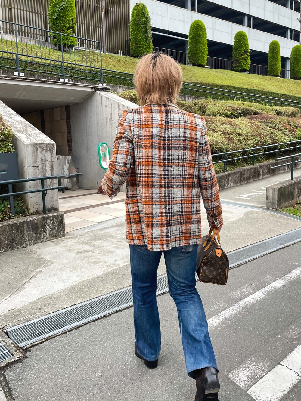 グレー系のテーラードジャケット、ブルー系のデニムパンツ、ブラック系のブーツを着用したメンズの秋コーディネートの5枚目の写真