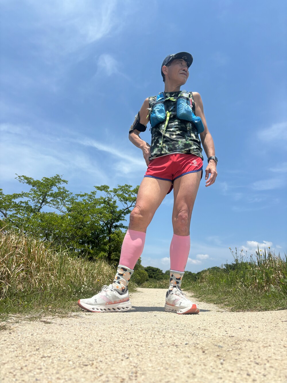 ホワイト系のスニーカー、ブルー系のバックパック/リュック、レッド系のその他パンツを着用したメンズの春コーディネートの2枚目の写真
