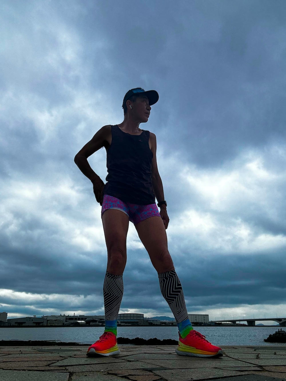 ブラウン系のタンクトップ、レッド系のスニーカー、ピンク系のレギンス/スパッツを着用したメンズの春コーディネートの4枚目の写真