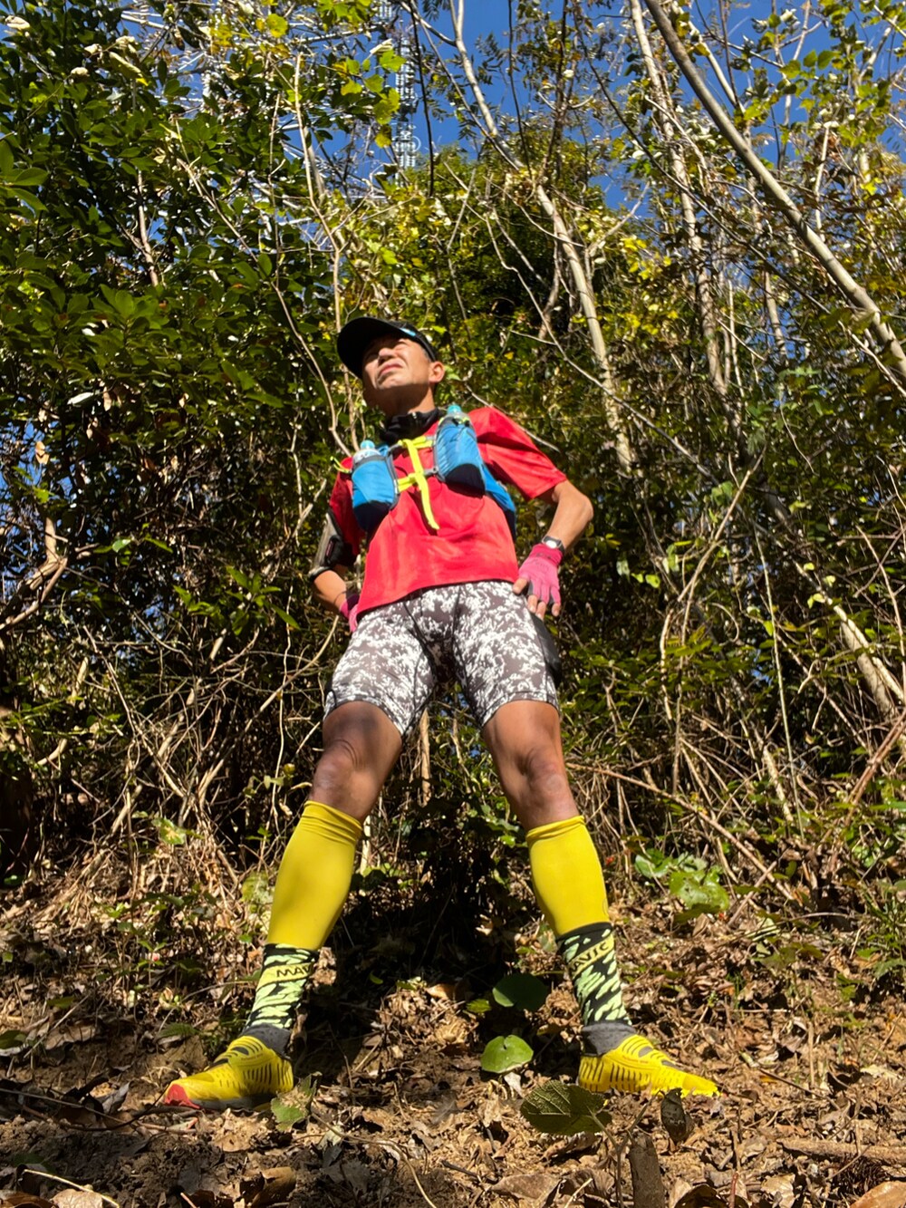 レッド系のTシャツ/カットソー、ブルー系のバックパック/リュック、イエロー系のその他シューズを着用したメンズの冬コーディネートの3枚目の写真