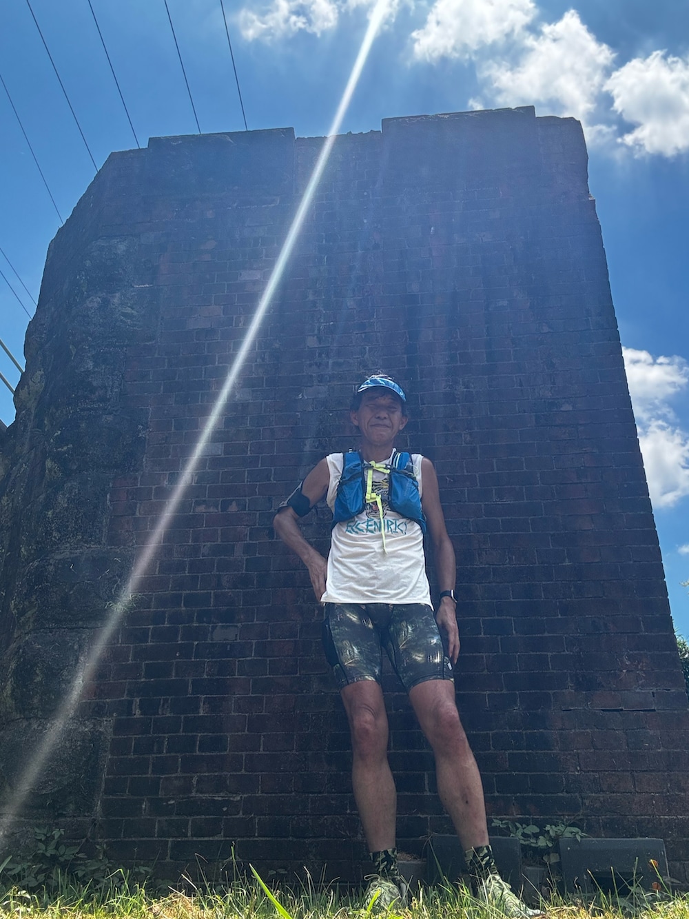 ホワイト系のタンクトップ、イエロー系のスニーカー、グレー系のタイツ/ストッキングを着用したメンズの夏コーディネートの3枚目の写真