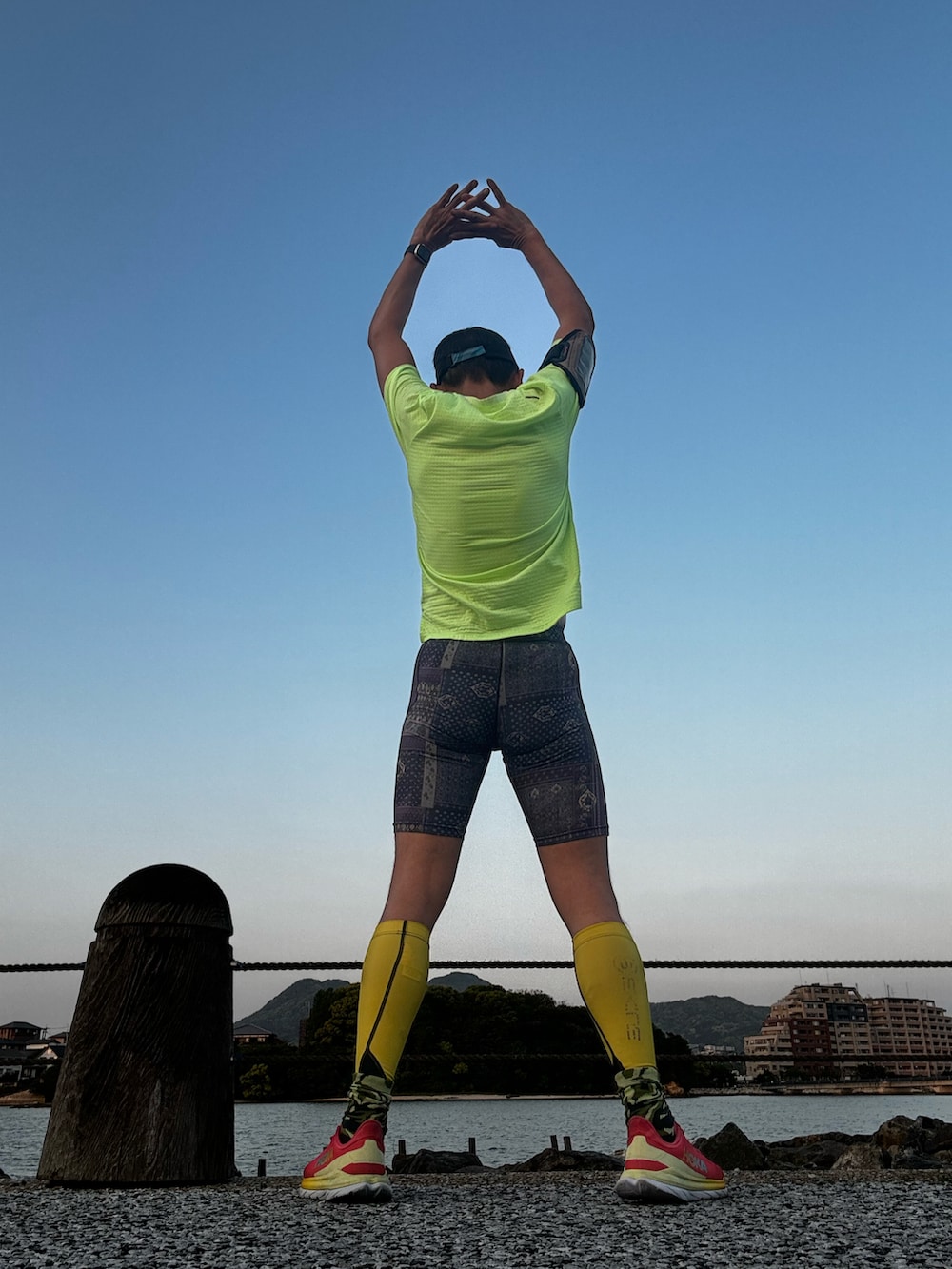 グリーン系のTシャツ/カットソー、レッド系のシューズ、シルバー系のレギンス/スパッツを着用したメンズの春コーディネートの2枚目の写真