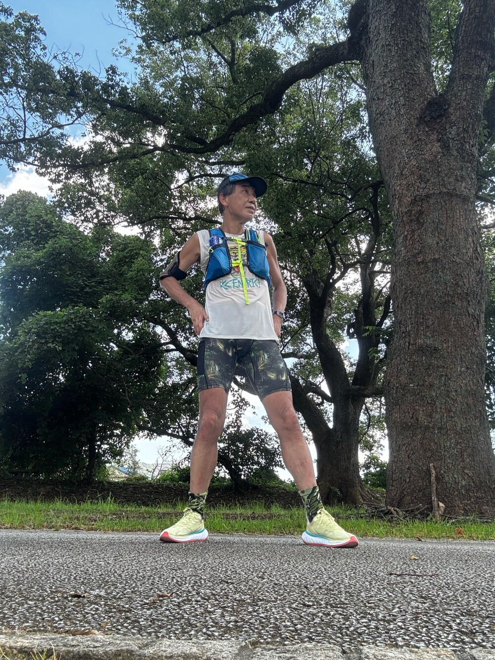 ホワイト系のタンクトップ、イエロー系のスニーカー、グレー系のタイツ/ストッキングを着用したメンズの夏コーディネートの2枚目の写真