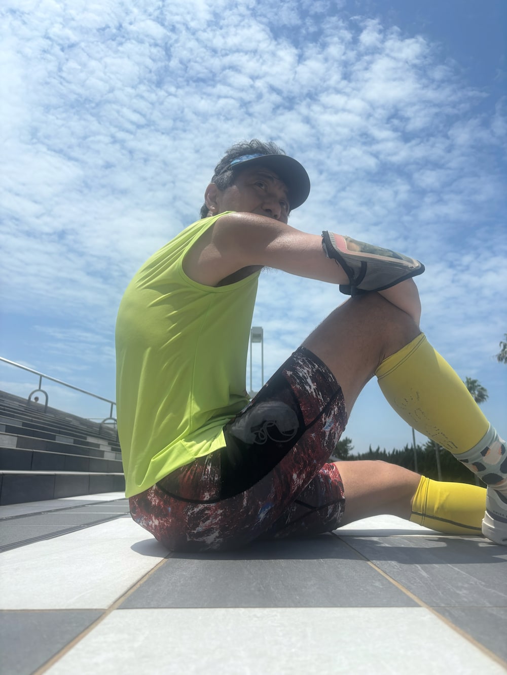 イエロー系のTシャツ/カットソー、ホワイト系のスニーカー、レッド系のレギンス/スパッツを着用したメンズの夏コーディネートの3枚目の写真