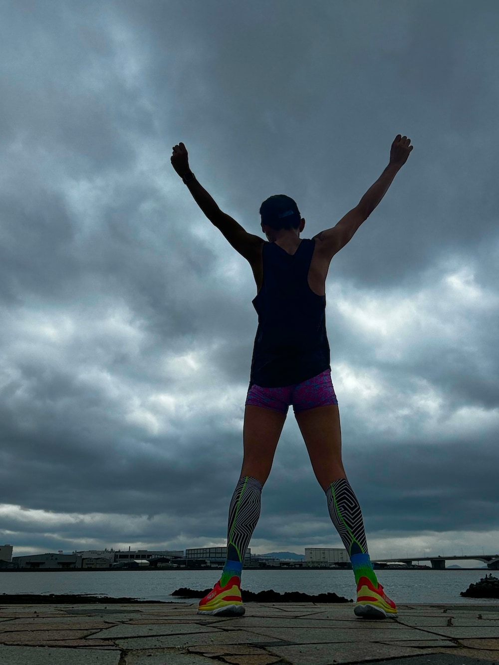 ブラウン系のタンクトップ、レッド系のスニーカー、ピンク系のレギンス/スパッツを着用したメンズの春コーディネートの3枚目の写真