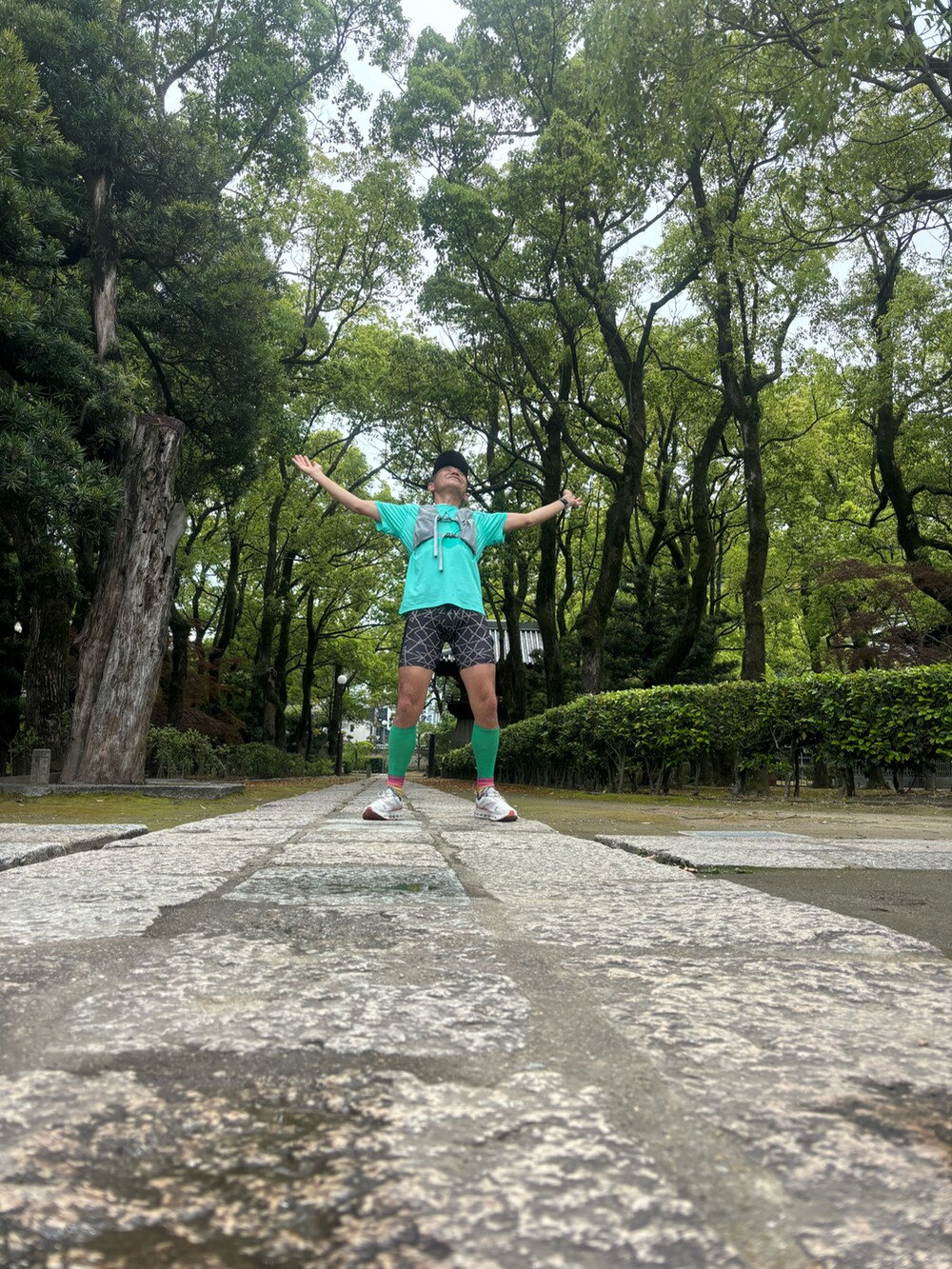 グリーン系のTシャツ/カットソー、ホワイト系のスニーカー、ブラック系のレギンス/スパッツを着用したメンズの春コーディネートの4枚目の写真
