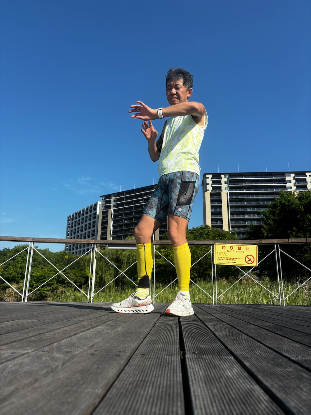 イエロー系のタンクトップ、ブルー系のレギンス/スパッツを着用したメンズの夏コーディネートの2枚目の写真
