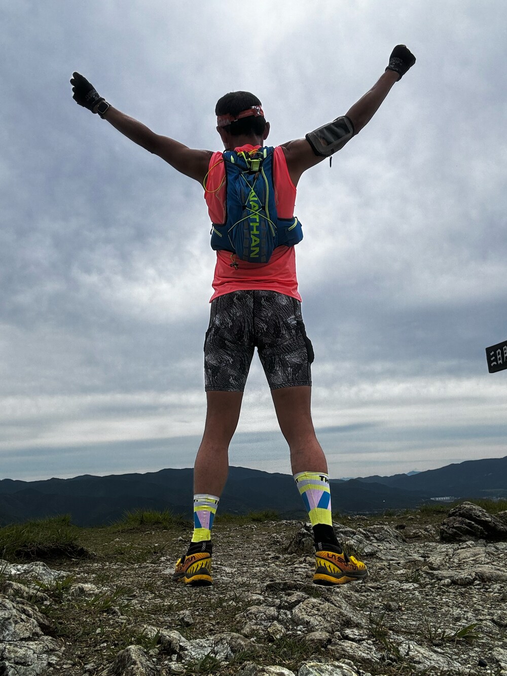 オレンジ系のTシャツ/カットソー、イエロー系のシューズ、オレンジ系のその他小物を着用したメンズの春コーディネートの5枚目の写真