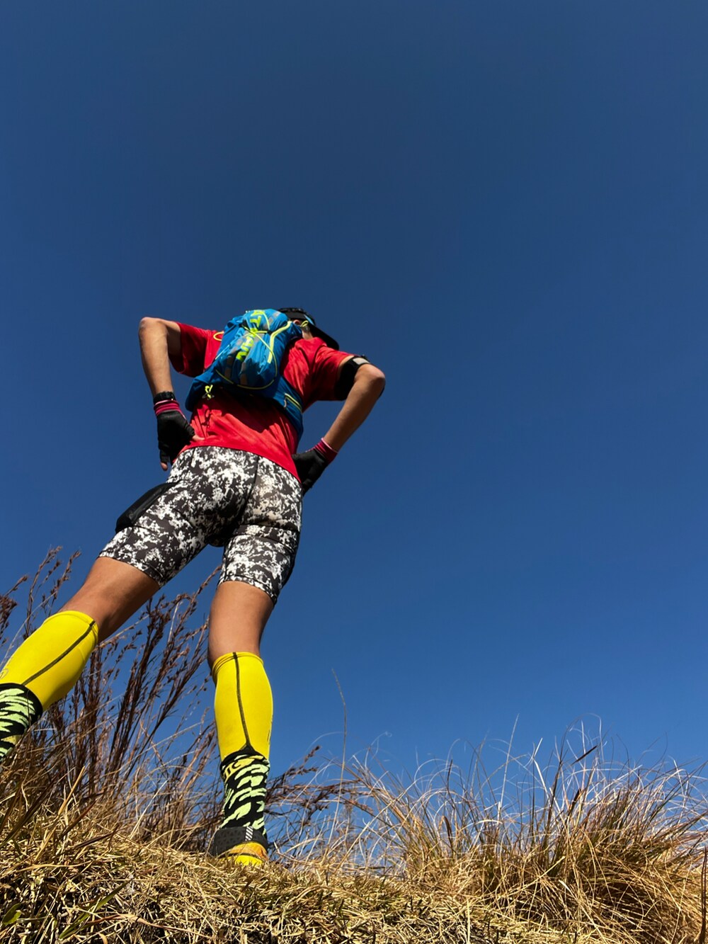 レッド系のTシャツ/カットソー、ブルー系のバックパック/リュック、イエロー系のその他シューズを着用したメンズの冬コーディネートの4枚目の写真