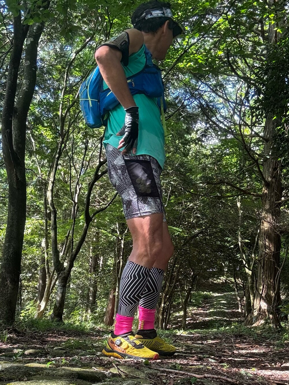 グリーン系のTシャツ/カットソー、シルバー系のレギンス/スパッツを着用したメンズの夏コーディネートの2枚目の写真