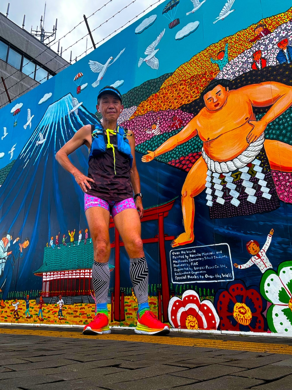 ブラウン系のタンクトップ、レッド系のスニーカー、ピンク系のレギンス/スパッツを着用したメンズの春コーディネートの2枚目の写真