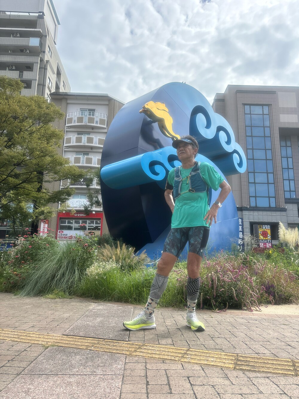 グリーン系のTシャツ/カットソー、グリーン系のスニーカー、ブルー系のレギンス/スパッツを着用したメンズの秋コーディネートの3枚目の写真