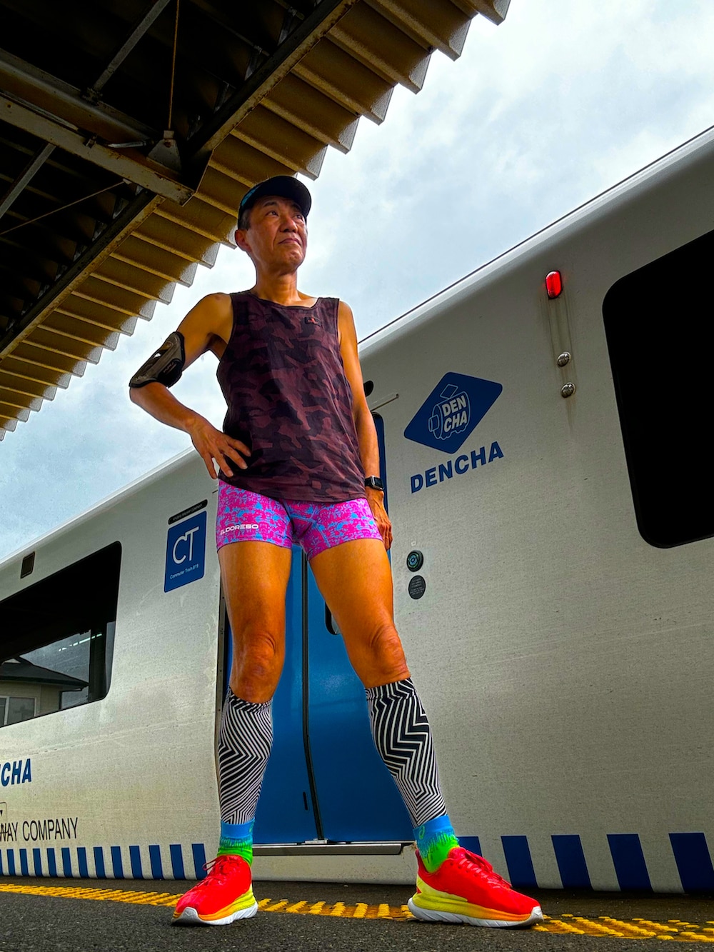 ブラウン系のタンクトップ、レッド系のスニーカー、ピンク系のレギンス/スパッツを着用したメンズの春コーディネートの5枚目の写真