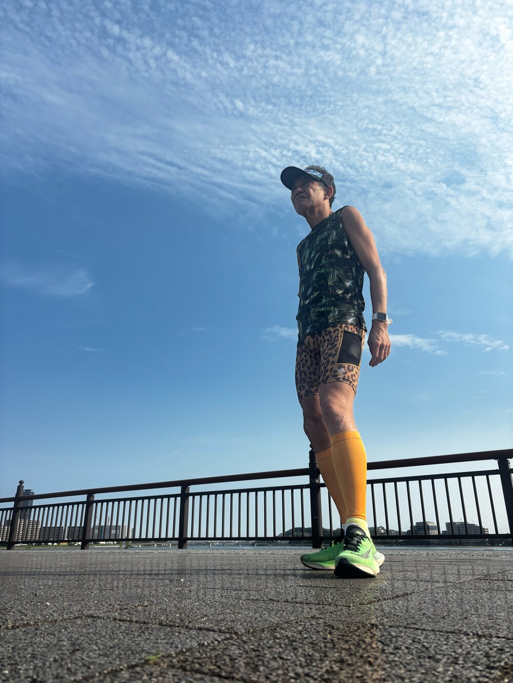 ブルー系のタンクトップ、ブラウン系のレッグウェアを着用したメンズの夏コーディネートの2枚目の写真