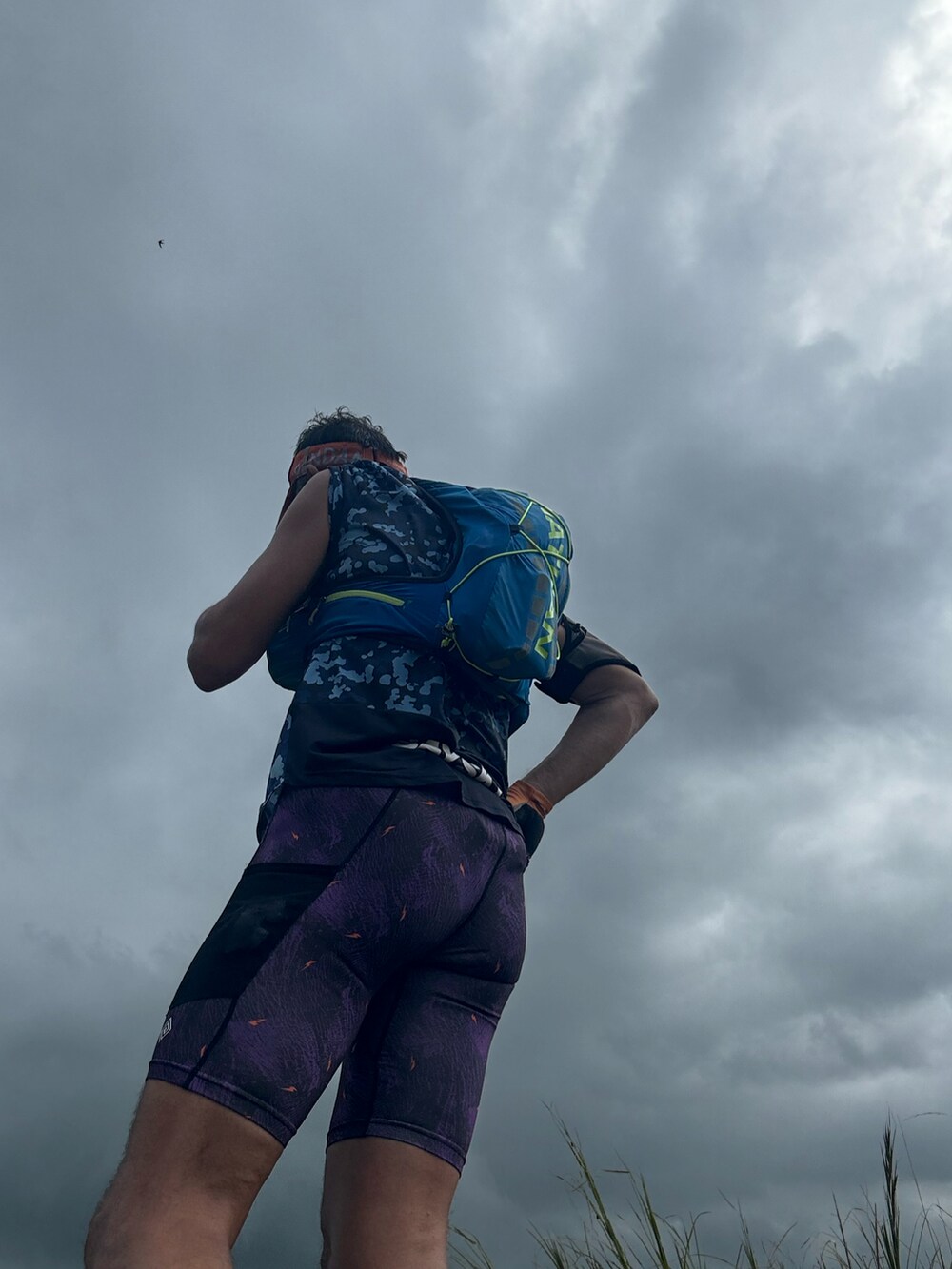 ブルー系のトップス、ブルー系のバックパック/リュック、パープル系のレギンス/スパッツを着用したメンズの夏コーディネートの2枚目の写真