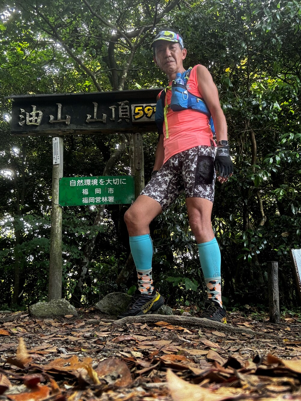 オレンジ系のTシャツ/カットソー、ブラック系のシューズ、シルバー系のレギンス/スパッツを着用したメンズの夏コーディネートの3枚目の写真