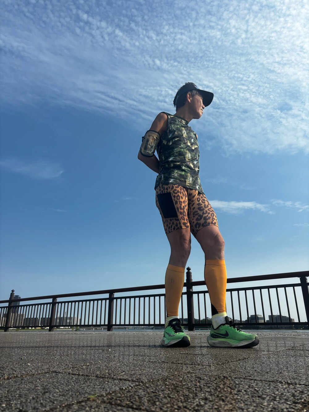 ブルー系のタンクトップ、ブラウン系のレッグウェアを着用したメンズの夏コーディネートの3枚目の写真