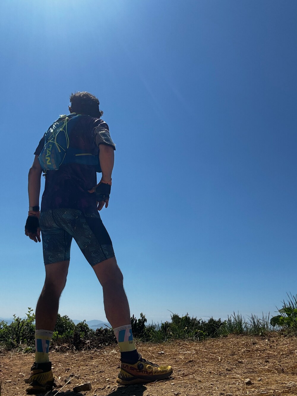 ブルー系のバックパック/リュック、パープル系のTシャツ/カットソー、イエロー系のその他シューズを着用したメンズの夏コーディネートの5枚目の写真