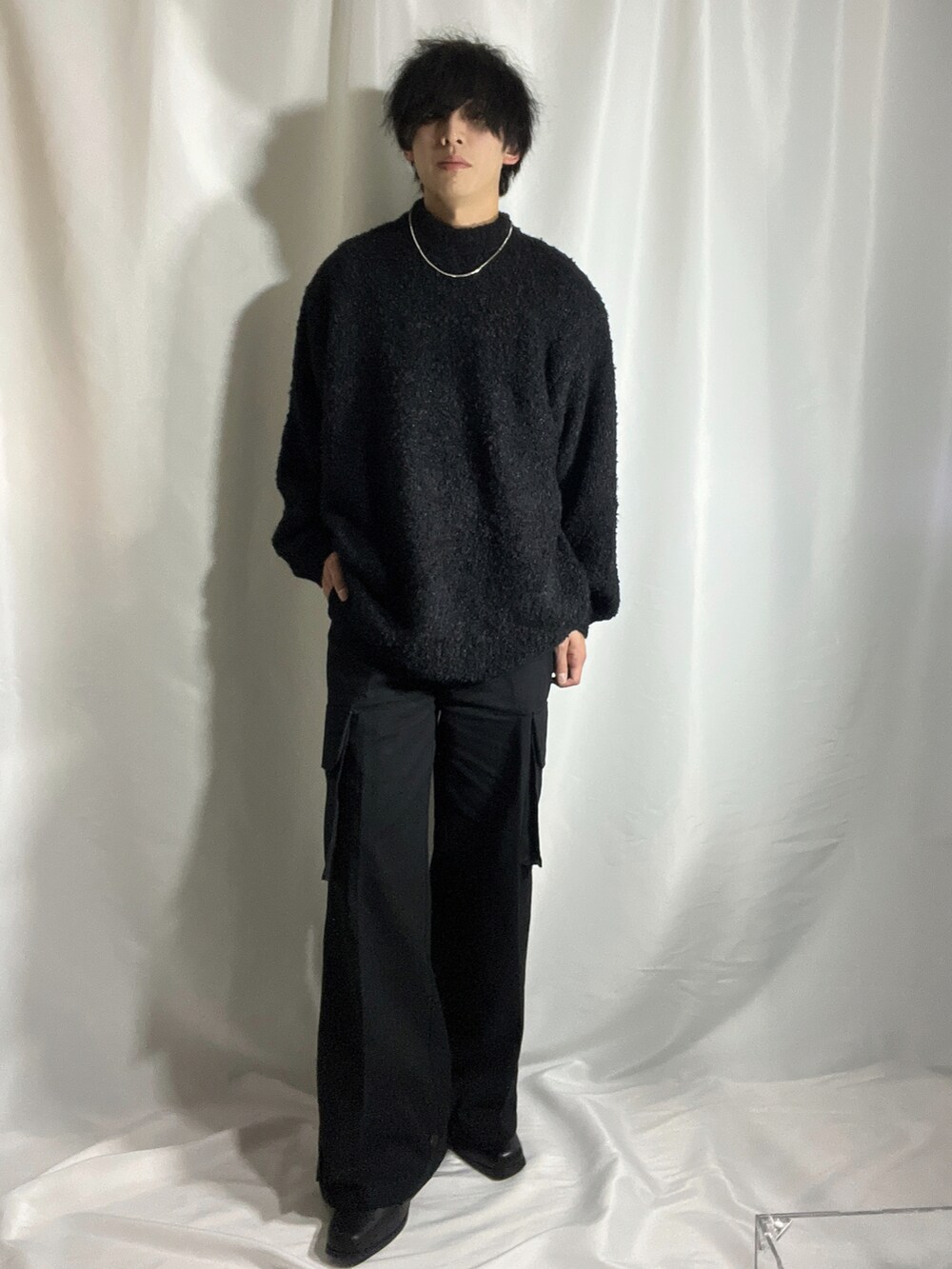 ブラック系のニット/セーター、ブラック系のカーゴパンツ、ブラック系のブーツを着用したメンズの秋コーディネートの4枚目の写真